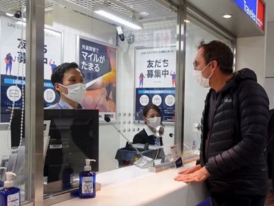 Photo of man greeting sales person through glass window